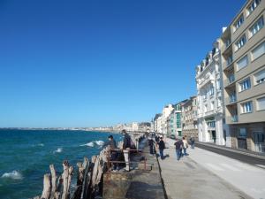 圣马洛SAINT MALO bel appartement plain pied 300 m gare prés plage du sillon Intramuros a pied的一群人走在海边人行道上