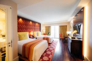 班加罗尔班加罗尔丽思卡尔顿酒店的酒店客房设有两张床和电视。