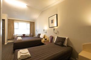 米塔贡米塔宫汽车旅馆的酒店客房设有两张床和窗户。