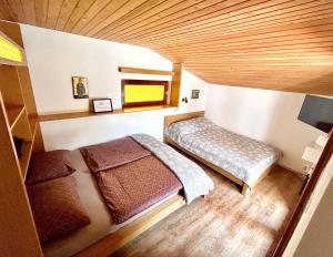 卢布尔雅那Family lake house Zbilje的一间卧室设有两张床和木制天花板