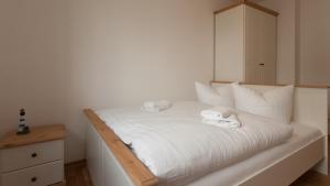 萨斯尼茨Stella in der Villa Amelie am Meer的一张白色的床,上面有两条毛巾