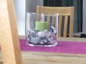 萨斯尼茨Stella in der Villa Amelie am Meer的满是岩石和一张桌子上的蜡烛的玻璃瓶