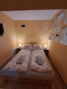 久洛Rozmaring Apartmanok的一间卧室设有两张床和两个床头柜