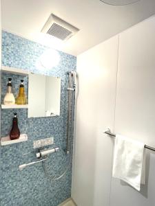 名户Ao Hotel的浴室设有蓝色瓷砖淋浴。