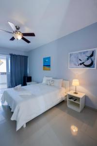 蓬塔卡纳Bella Vida Hotel Punta Cana的卧室配有白色的床和吊扇