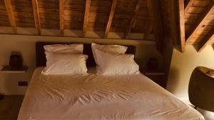 那慕尔La conciergerie的卧室内的一张带白色床单和枕头的床