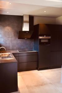 那慕尔La conciergerie的厨房配有黑色橱柜和水槽