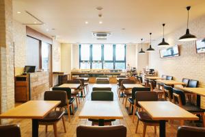 东京hotel MONday Tokyo Nishikasai的餐厅设有桌椅和窗户。