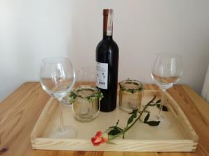 NurW Łęgu Natury的木桌旁的一瓶葡萄酒和两杯酒