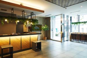 东京ICI HOTEL Ueno Shin Okachimachi的餐厅大堂设有种植了植物的酒吧