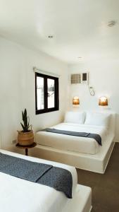 卢纳将军城Hostel Bajala Siargao的白色墙壁客房的两张床