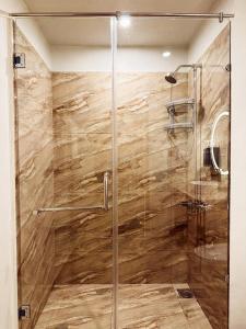 ShigarKhoj Resorts的浴室里设有玻璃门淋浴