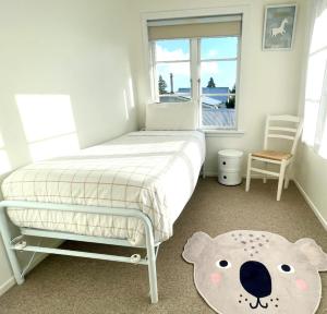 奥克兰Alta House的卧室配有带泰迪熊地毯的床
