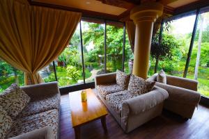 库塔巴厘岛花园海滩假日酒店的带沙发、桌子和窗户的客厅