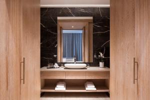 多哈The Bentley Luxury Hotel & Suites的一间带水槽和镜子的浴室