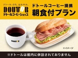 长冈HOTEL LiVEMAX Nigata Nagaoka Station的咖啡旁盘子里的三明治