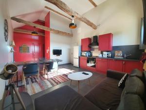 萨尔拉拉卡内达Gîte Le Clos de la Canéda的带沙发的客厅和带红色橱柜的厨房