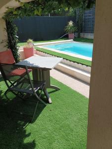 阿格德MimiLou rez-de-jardin avec piscine & spa的游泳池旁的桌子和椅子