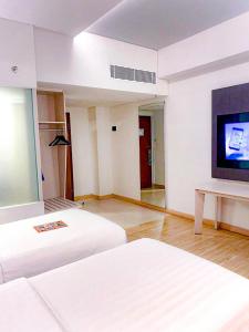 巨港Harper Palembang by ASTON的酒店客房设有两张床和一台平面电视。
