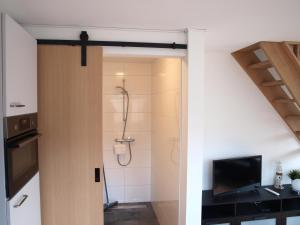 佐特兰德Appartement ,Vakantiewoning, Koddelaan 29的一间带淋浴的浴室和一台电视机