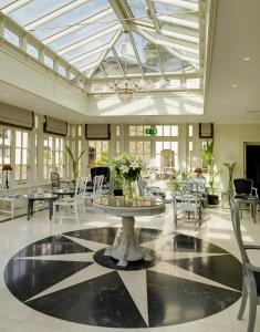 基拉尼Killarney Heights Hotel的配有桌椅和玻璃天花板的房间