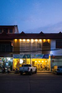 南府Paknap Hostel的夜间停在大楼前的汽车