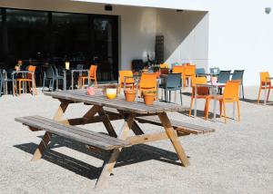 布鲁瓦布鲁瓦第一酒店的一张带橙色椅子和桌子的木制野餐桌