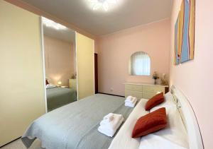 佩斯基耶拉德加达Appartamento 2, Villa Magnolia, 64mq, Lago di Garda的一间卧室配有一张带红色枕头和镜子的床