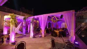 穆扎夫法尔普尔Ratna Hotel & Banquet的婚礼场地,配有紫色灯光和桌子