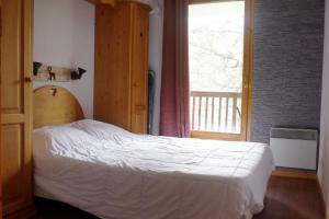 瓦尔Spacieux et Fonctionnel dans Ecrin des Neiges的卧室配有白色的床和窗户。