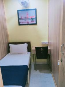 孟买Royal Cabin Stay的小房间设有一张床和一张书桌