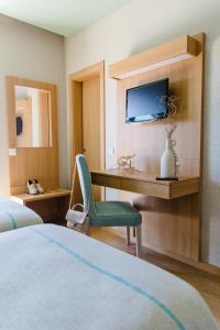 法蒂玛Hotel Santo António de Fátima的酒店客房设有一张床和一张带电视的书桌。