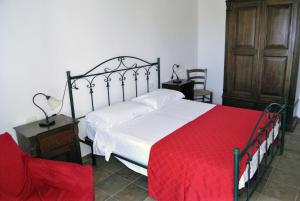 圣伊西多罗Agriturismo La Lucia的一间卧室配有一张带红色毯子的大床