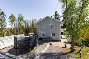 Spacious accommodation near Stockholm with heated pool的前面有篮球架的房子