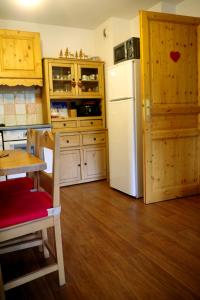 瓦尔Spacieux et Fonctionnel dans Ecrin des Neiges的厨房配有白色冰箱和木制橱柜。