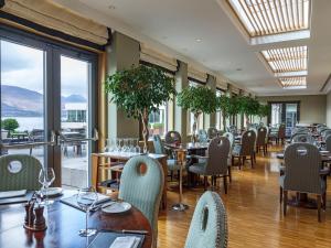 基拉尼欧罗巴假日酒店的餐厅设有桌椅和窗户。