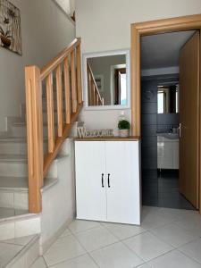 帕纳基雅Lagom House的浴室设有楼梯和带镜子的白色橱柜