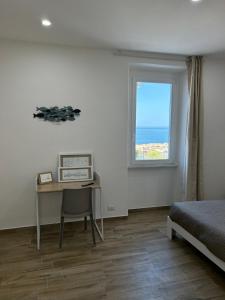 奇维塔韦基亚Stella di Mare的一间卧室配有一张床、一张书桌和一个窗户。