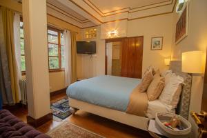 甘托克Amritara 5 BHK Luxury Villa, Gangtok的一间卧室配有一张床、一张沙发和一台电视