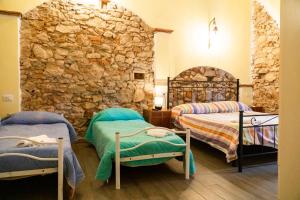 坎丕里亚麦利蒂玛Affitta Camere Lido&Lida的石墙客房的两张床