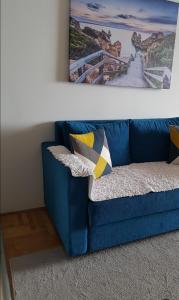 布德瓦The rising sun的客厅里一张蓝色的沙发,墙上挂着一幅画
