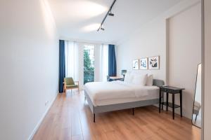 伊斯坦布尔Homie Suites - Luxury Apartments in Maçka的白色卧室配有床、书桌和椅子