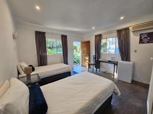 贝拉贝拉Thuto Centre Conferencing & Bush Lodge的酒店客房配有两张床和一张书桌