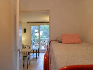 圣艾格夫Studio cabine avec piscine, tennis et parking à 400m de la plage - 4 couchages, Saint-Aygulf - FR-1-226A-89的一间卧室配有一张床,享有庭院的景色