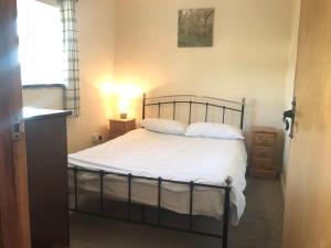 曼海德Recently renovated 3-Bed Apartment on Exmoor的一间卧室配有带白色床单和枕头的床。