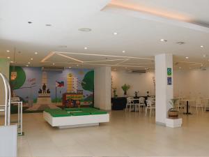 马尼拉Go Hotels Ermita, Manila的一间带桌椅的餐厅和一间房间