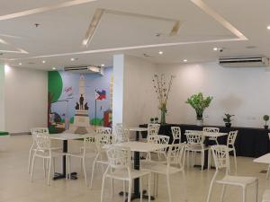 马尼拉Go Hotels Ermita, Manila的用餐室配有白色的桌子和白色的椅子