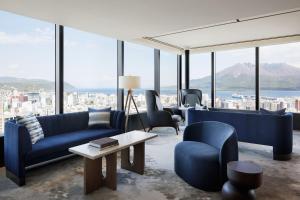 鹿儿岛Sheraton Kagoshima的客厅配有蓝色的家具,享有城市美景