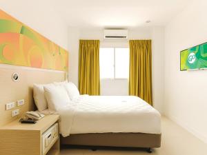 马尼拉Go Hotels Timog的酒店客房设有床和窗户。