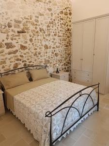 维科德尔加尔加诺Arcaroli Borgo Vico "Exclusive"的一间卧室设有一张床和石墙